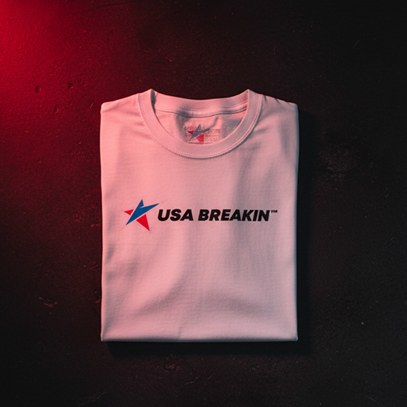 Folded white t-shirt with 'USA BREAKIN' logo on a dark surface